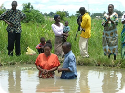 Ps Millan baptising in one of his 'multi purpose' fish ponds